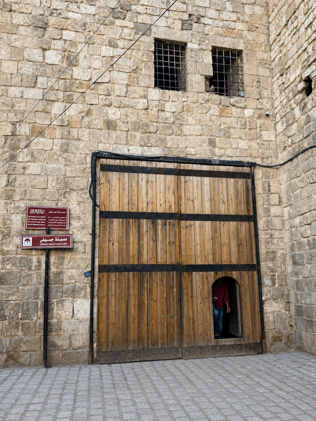 The wooden entrance door of the Jebeili Soap Factory in the Old City of Aleppo, with the family sign